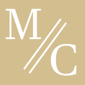 White letters "M" and "C" separated by two diagonal lines on a beige background.