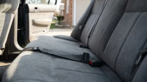 unfastened seat belt lying across rear passenger seat of vehicle